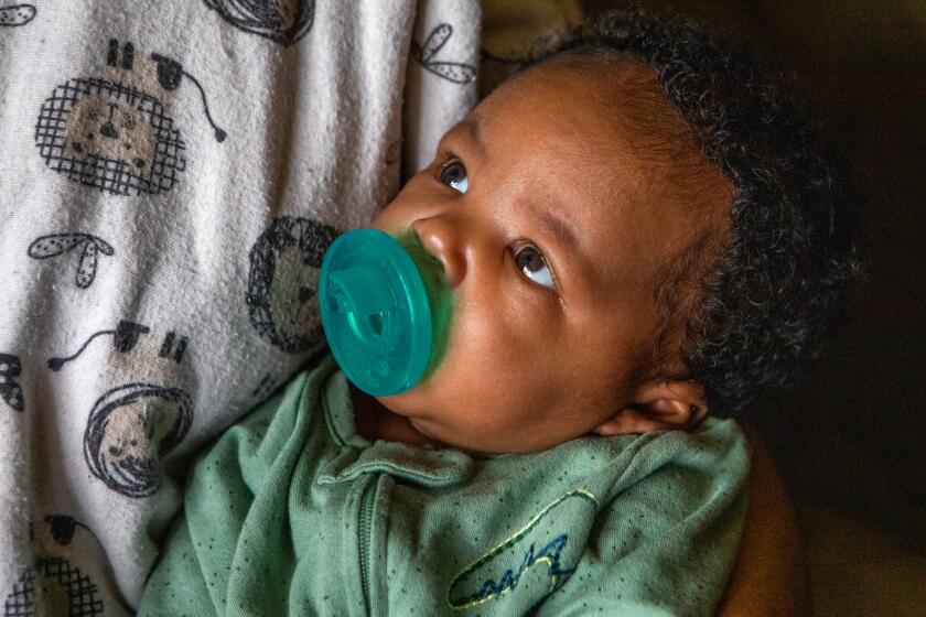 Compton, CA - June 15: Newborn Braylen Rollins keeps a watchful eye on his mother Christiana Layne in their home on Thursday, June 15, 2023, in Compton, CA. A new study finds that fathers can make a huge difference in determining whether their baby is successfully breastfed and put to sleep safely. Danny Rollins in Compton is the enthusiastic father of their five-week-old baby boy. Rollins doing everything he can to be supportive. (Francine Orr / Los Angeles Times)