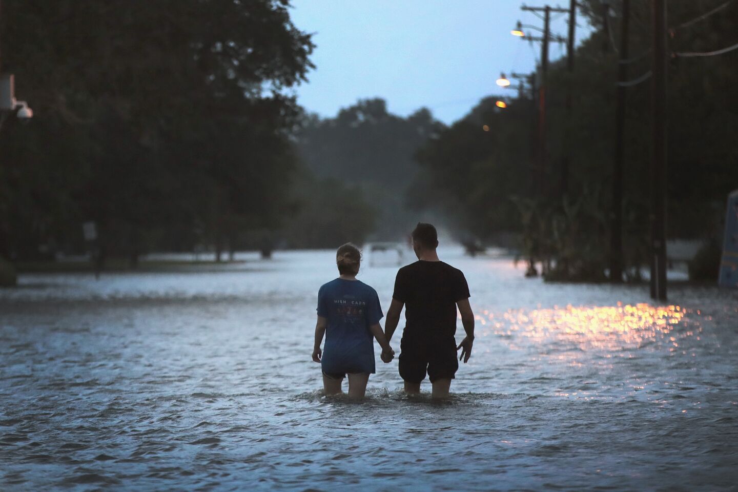A couple stroll down Lakeshore Drive near Lake Pontchartrain after it was flooded in the wake of Hurricane Barry.