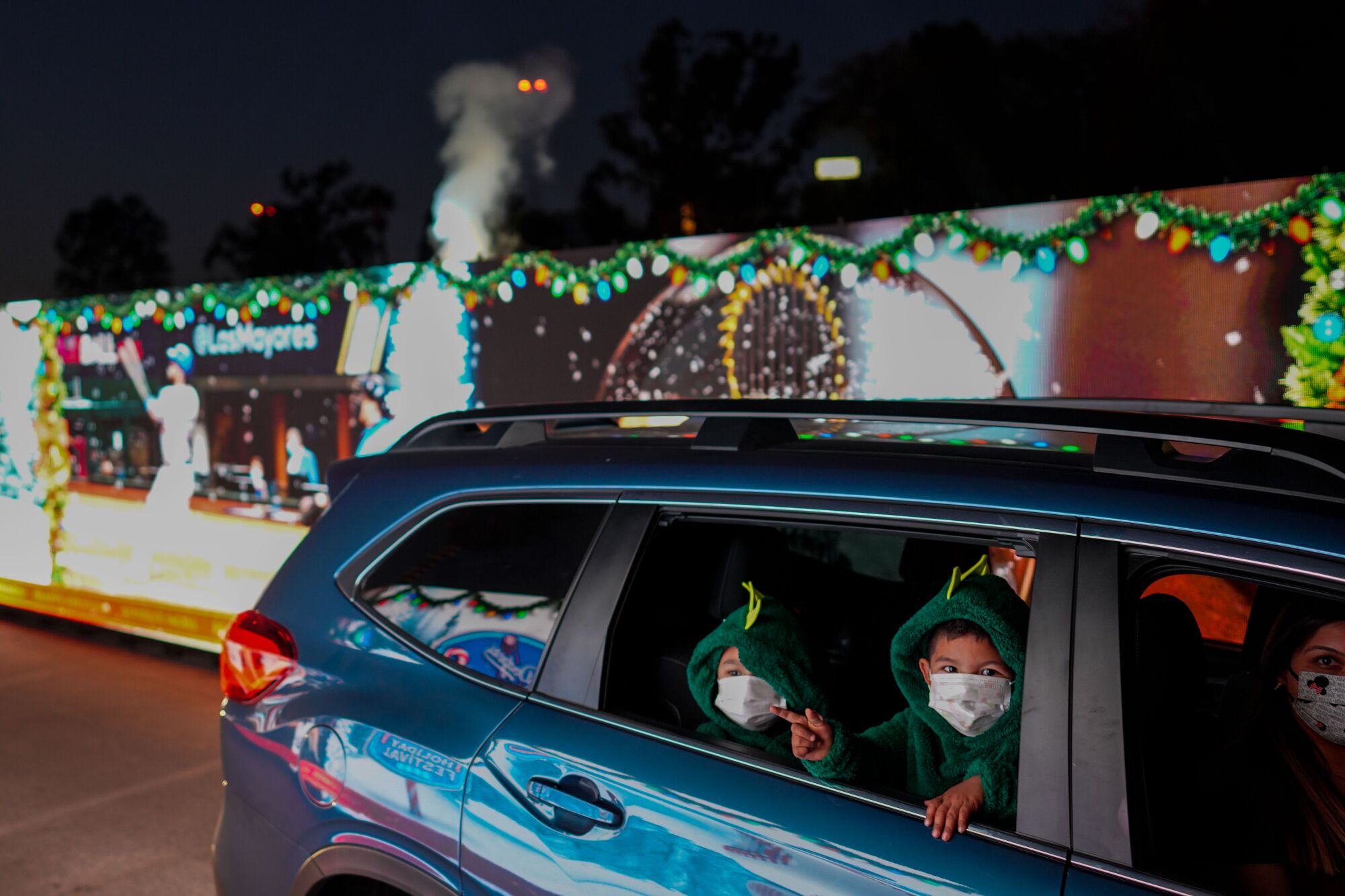 Children watch the Dodger's Holiday Festival 2020 from a car window at Dodger Stadium