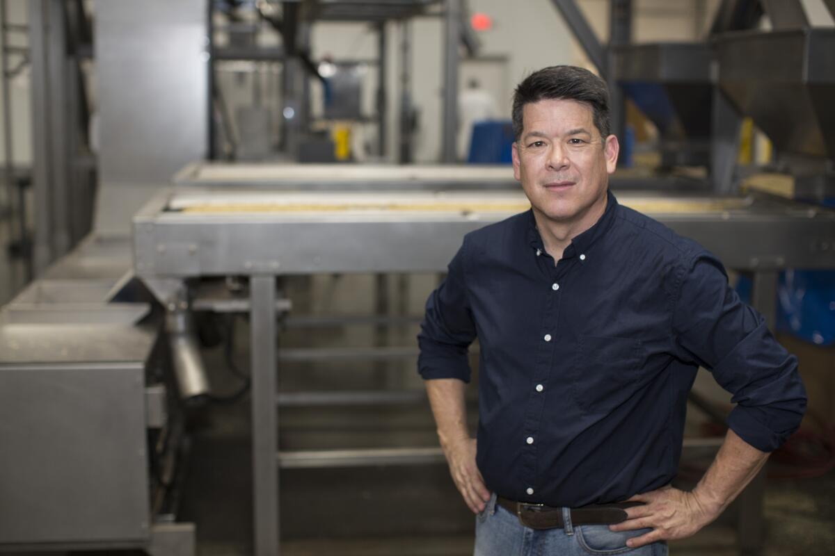 A man stands with his hands on his hips in an industrial facility.