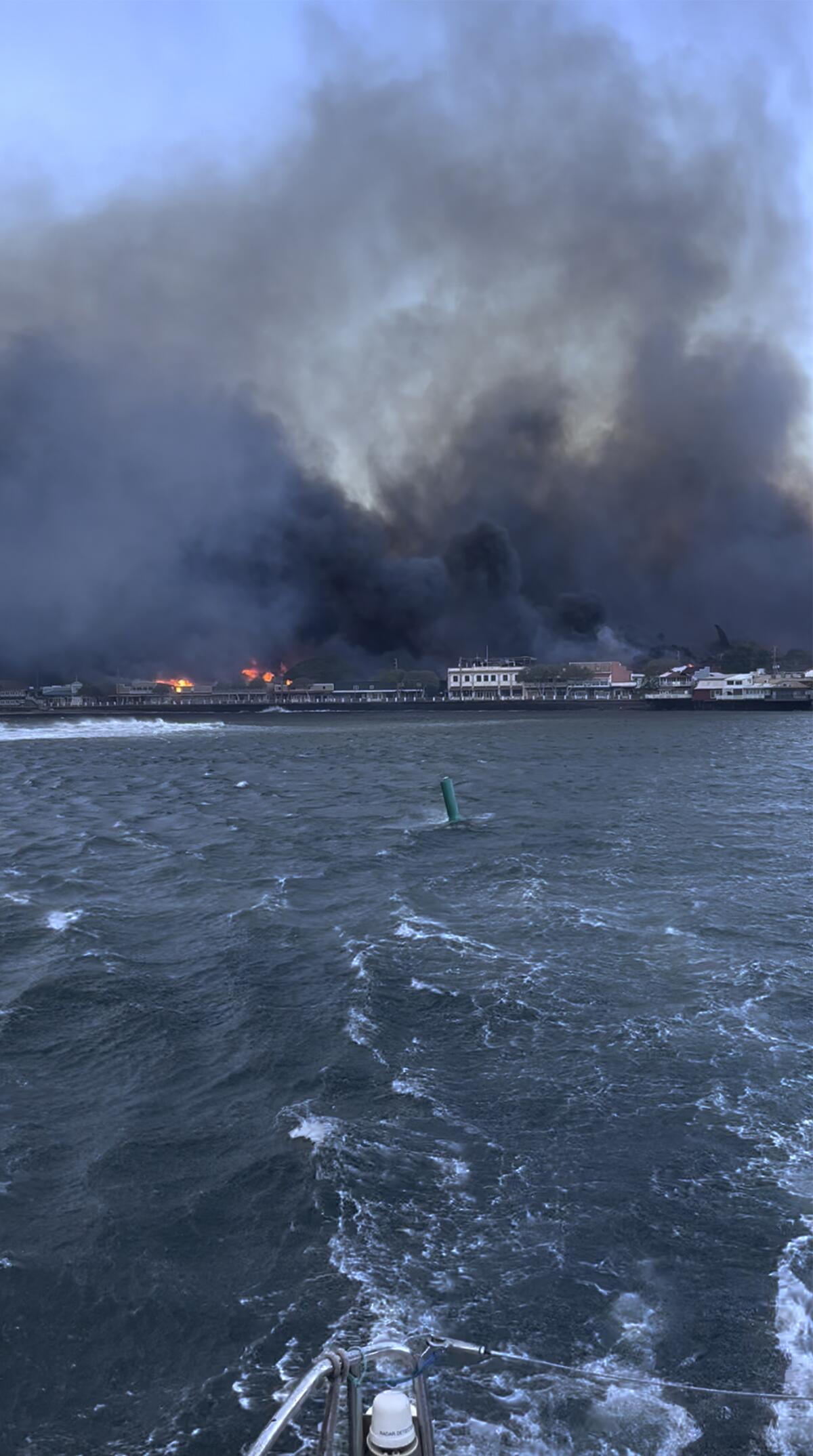 Smoke fills a harbor as seen from the water.