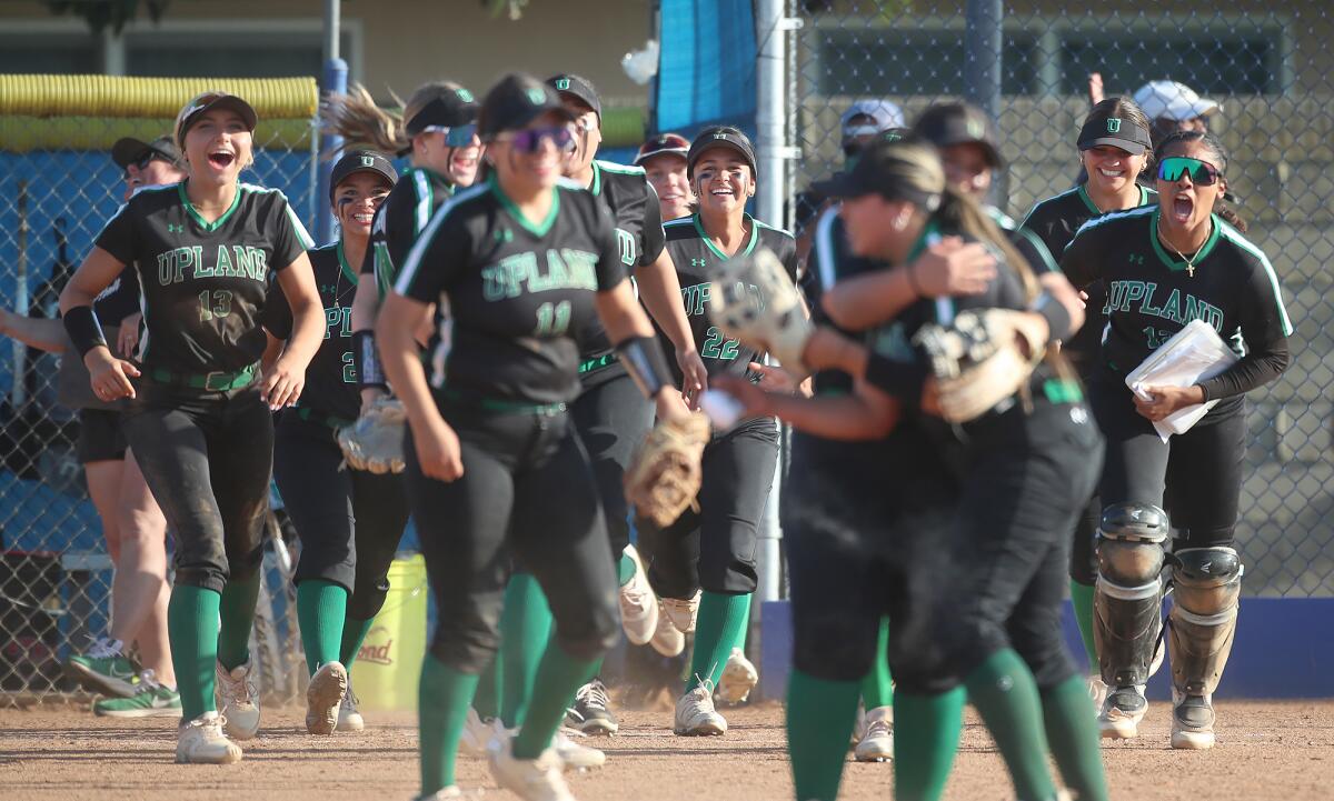The Upland softball team pours out of the dugout after defeating Fountain Valley on Tuesday.