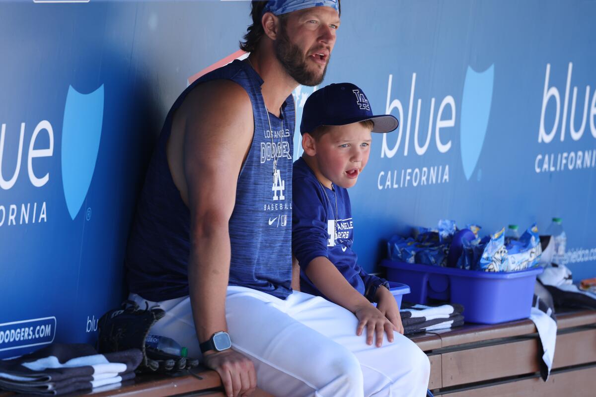 Clayton Kershaw and his son, Charley watch the Houston Astros take batting practice on June 25, 2023, at Dodger Stadium.