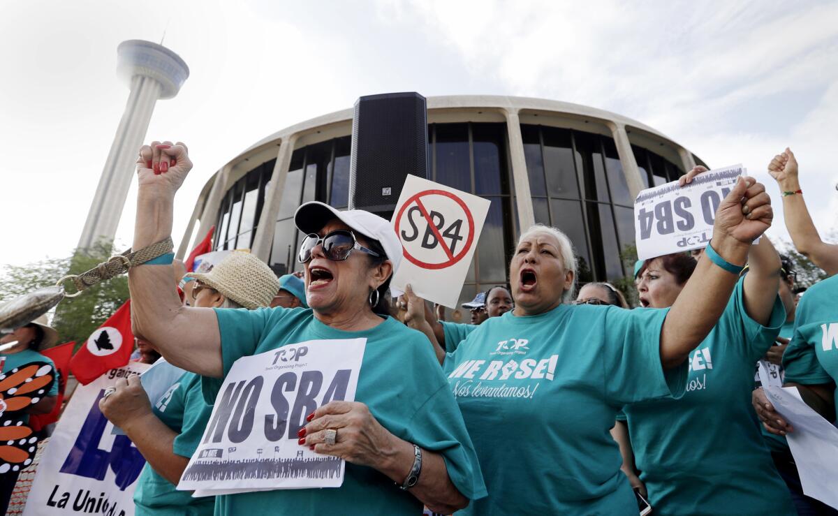 Lydia Balderas, left, and Merced Leyua join others at a protest against a "sanctuary cities" bill outside federal court in San Antonio in June.