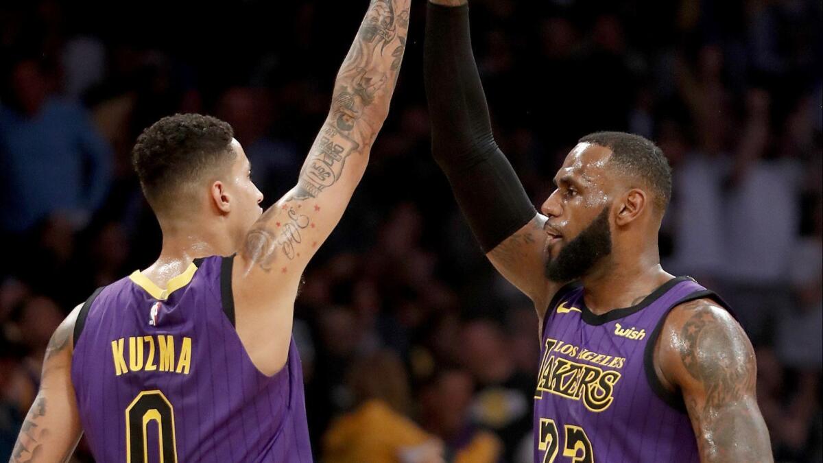Lakers' Kyle Kuzma and LeBron James celebrate a basket in the first half on Wednesday at Staples Center.