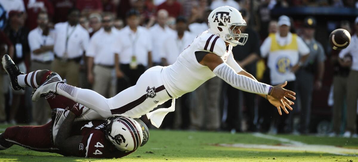 Texas A&M quarterback Kenny Hill throws a shovel pass as South Carolina defensive end Gerald Dixon pulls him down during the first half of a game Thursday at Williams-Brice Stadium in Columbia, S.C.