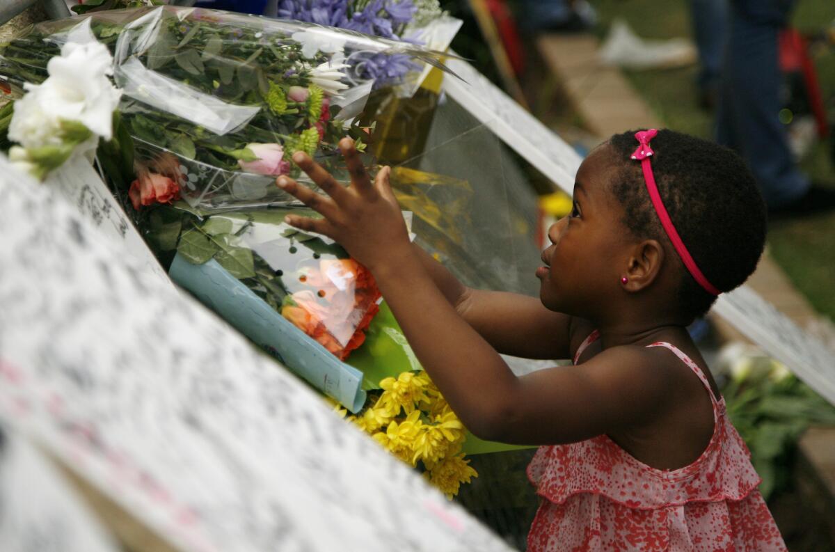 A young girl places flowers outside the home of former South African President Nelson Mandela in Johannesburg.