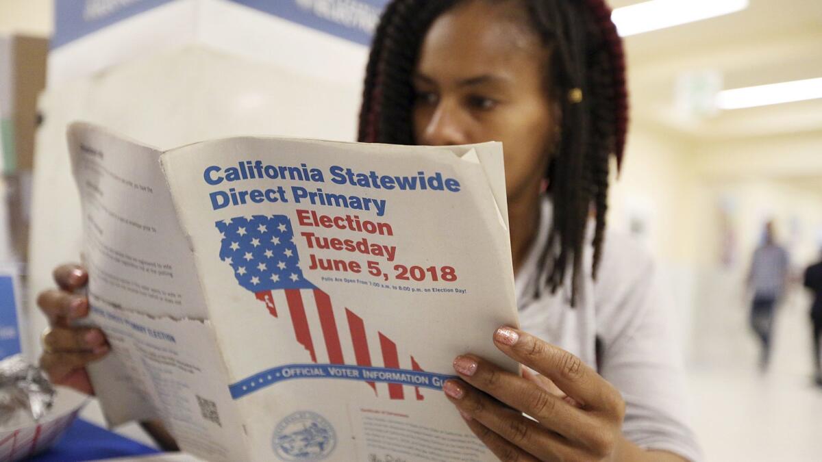 Nikko Johnson reviews the election guide at San Francisco City Hall on June 5.