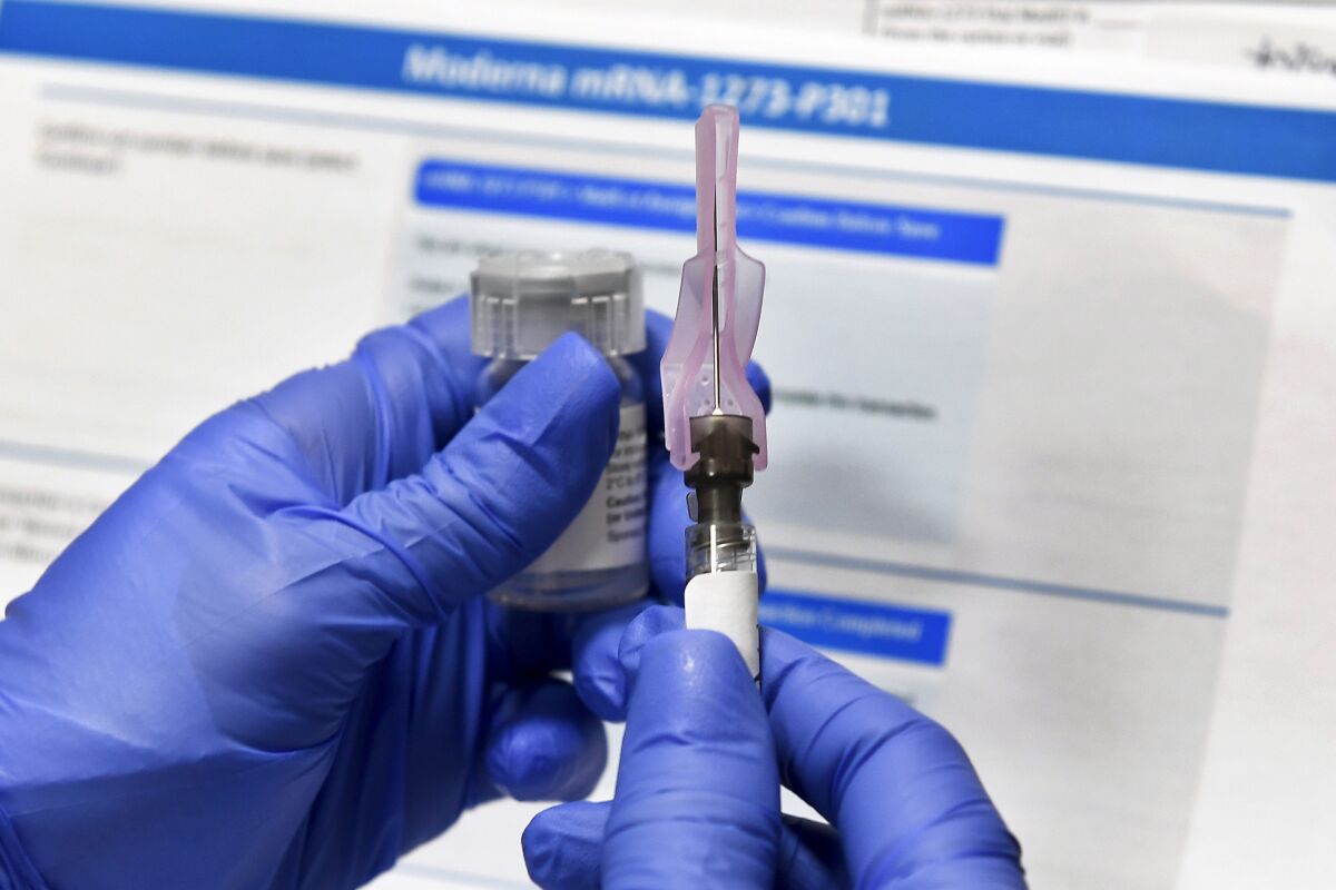 A nurse prepares a syringe during a study of a  COVID-19 vaccine. 