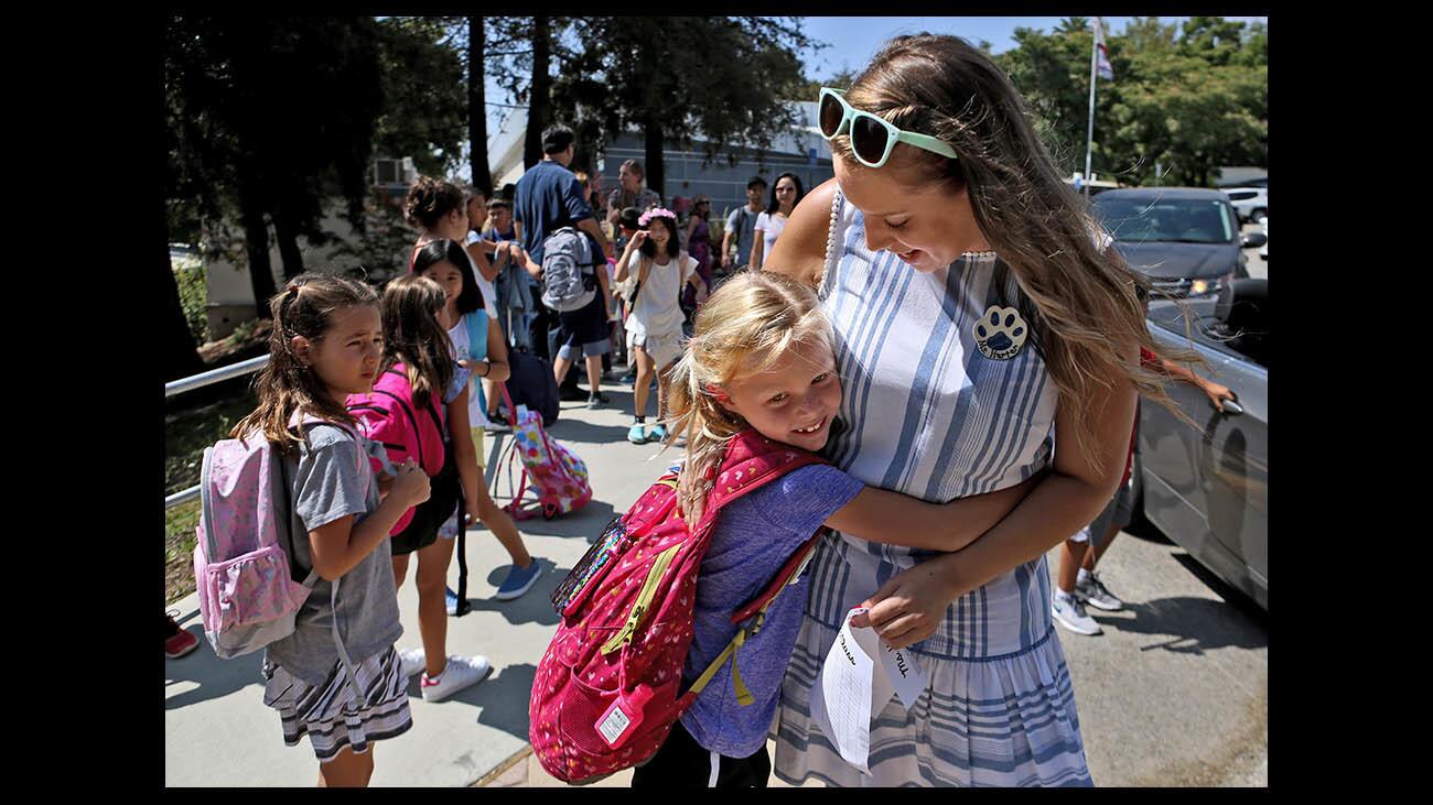 Second grader Eden Kingston gives her former and first grade teacher Rachel Harter on the first day of school at Palm Crest Elementary School in La Canada Flintridge on Thursday, Aug. 16, 2018.