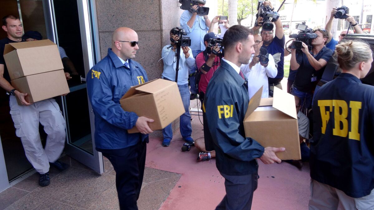 FBI agents take boxes with documents from the CONCACAF headqueartes in Miami Beach, Fla, on Wednesday.