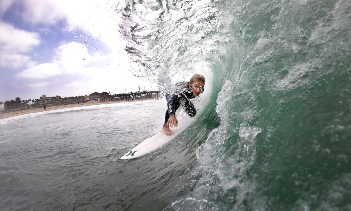 Luke Guinaldo, 13, of Huntington Beach, gets a tube ride after the blessing of the surfers during the first-ever California Surfing Day celebration at the Huntington Beach pier.