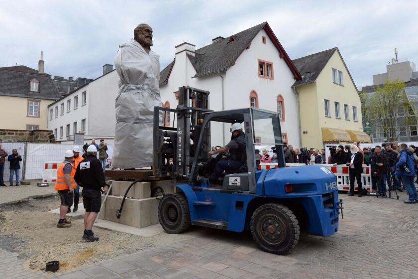 Workers install a statue of German philosopher, economist, political theorist and sociologist Karl Marx on April 13, 2018 in Trier, Germany, as the statue by Chinese artist Wu Weishan will remain covered until its official inauguration on May 5, 2018. The bronze statue created by Chinese artist Wu Weishan is weighing 2,3 tons and measures 4,40 meters. It is a present of the People's Republic of China to the city of Trier, where Marx was born 200 years ago, on May 5, 1818. / AFP PHOTO / dpa / Harald Tittel / - Germany OUTHARALD TITTEL/AFP/Getty Images ** OUTS - ELSENT, FPG, CM - OUTS * NM, PH, VA if sourced by CT, LA or MoD **