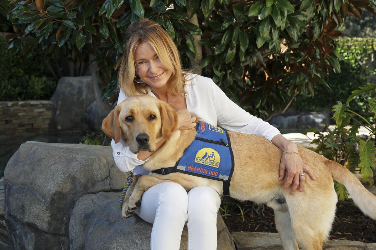Newport Beach resident Lisa Westerhout, 48, with hearing dog Arrow, her 3-year-old yellow Labrador/Golden Retriever mix.
