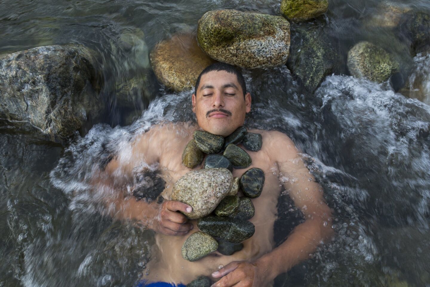 Melvin Marquez from Honduras, relaxes after having a bath in a river in Pijijiapan, Mexico.