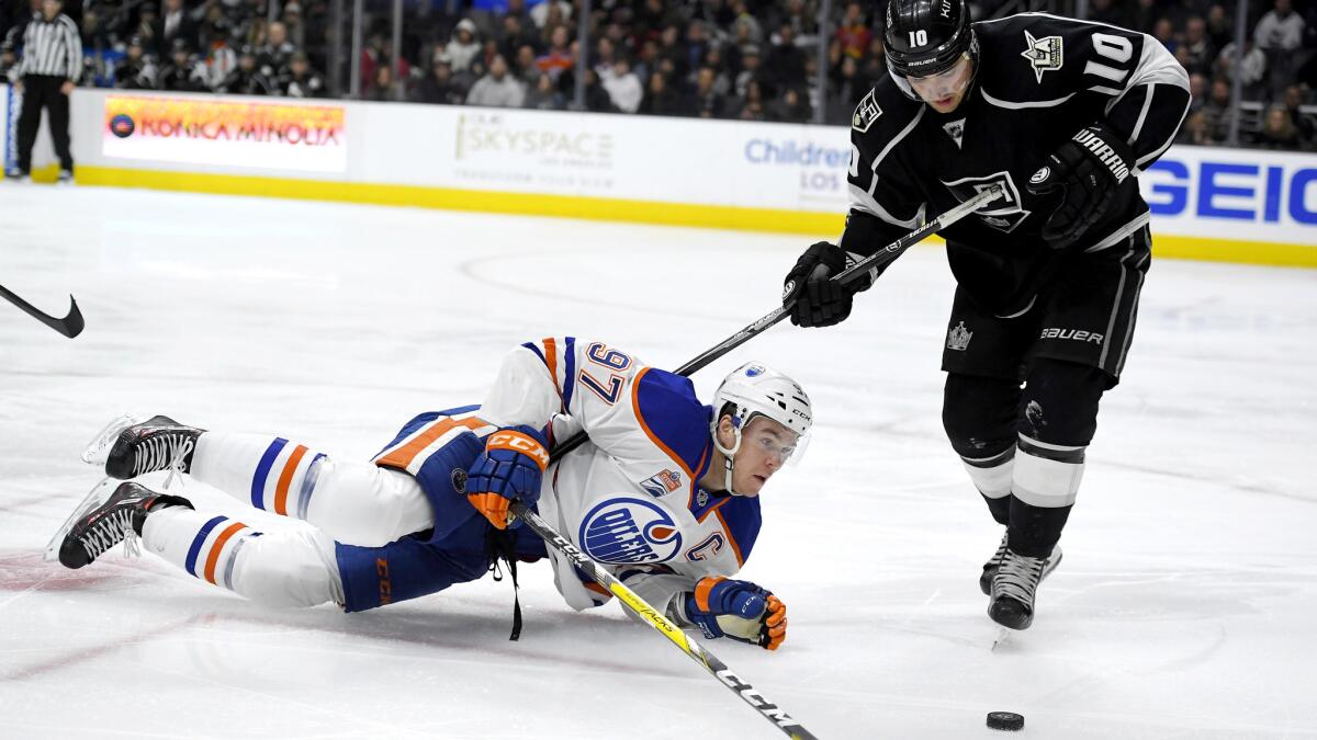 Kings right wing Devin Setoguchi tries to steal the puck after center Connor McDavid falls to the ice during play Thursday night.