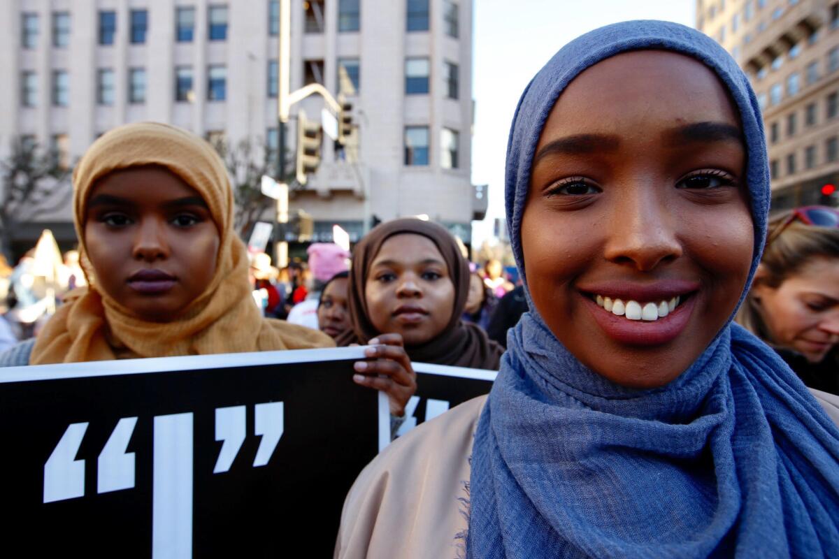Asha Isse, 19, from left, Bilqis Kulungu, 19, and Safiya Hussein, 20, of Los Angeles arrive downtown to participate in the women's march.