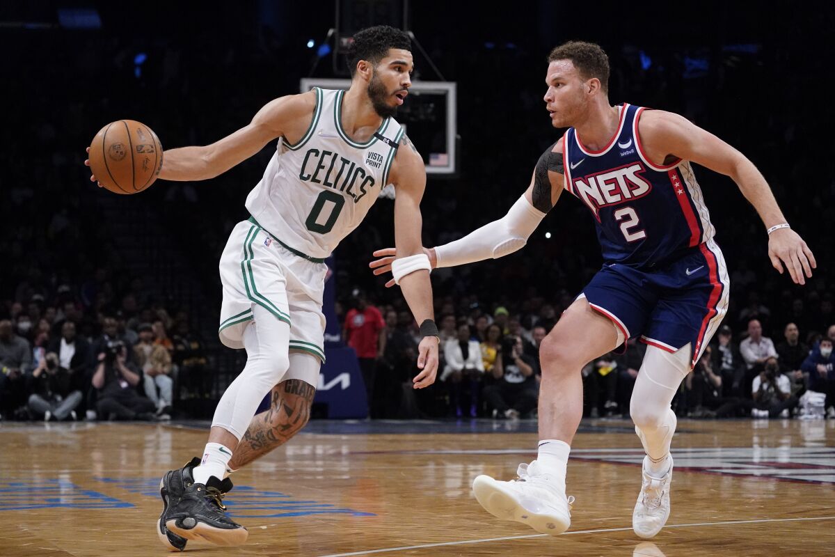 ARCHIVO - Jayson Tatum (0), de los Celtics de Boston, enfrenta a Blake Griffin (2), de los Nets de Brooklyn, en partido del lunes 25 de abril de 2022, en Nueva York. (AP Foto/John Minchillo, archivo)