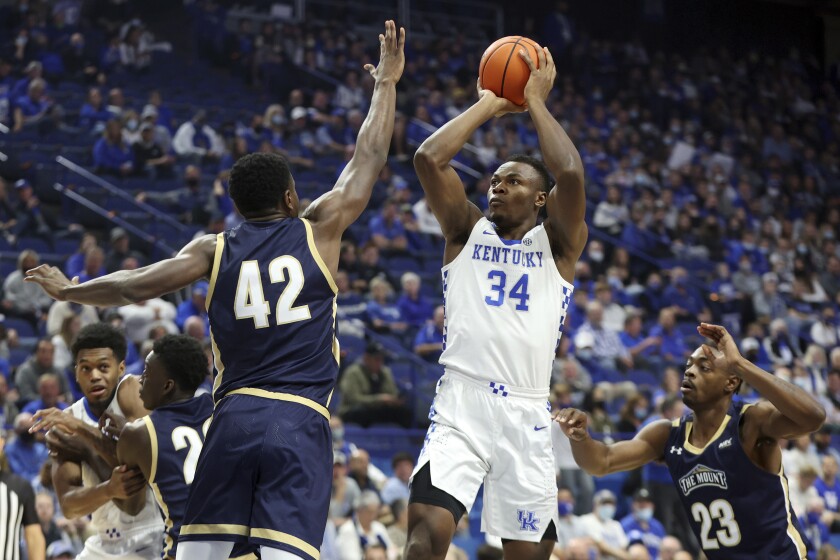 FILE - Kentucky's Oscar Tshiebwe (34) shoots between Mount St. Mary's Malik Jefferson (42) and Josh Reaves (23) during the first half of an NCAA college basketball game in Lexington, Ky., Tuesday, Nov. 16, 2021. Tshiebwe is the unanimous pick as The Associated Press player of the year in the Southeastern Conference, announced Tuesday, March 8, 2022. (AP Photo/James Crisp, File)