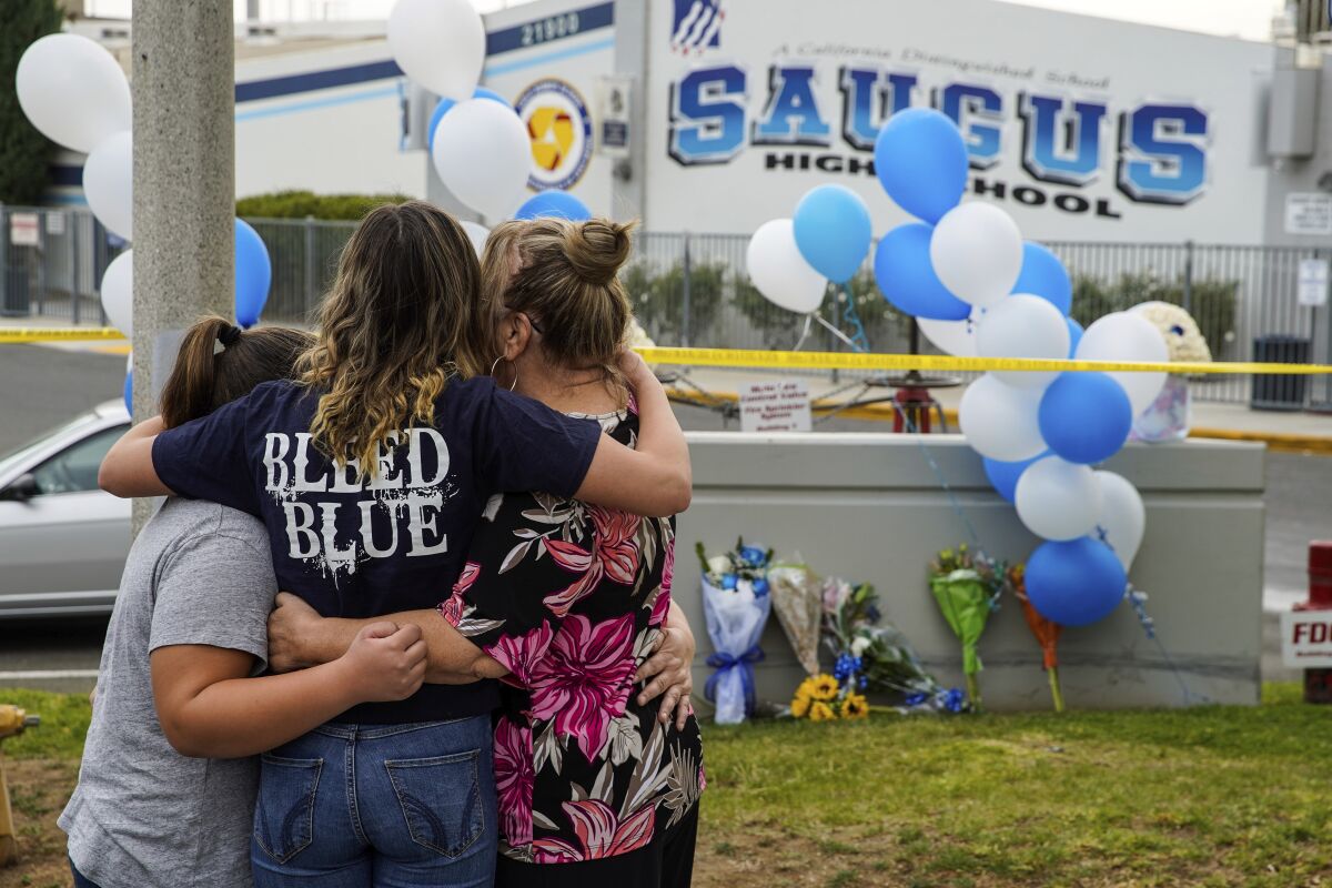 Une famille se rassemble à un mémorial à l'extérieur du lycée Saugus en 2019.