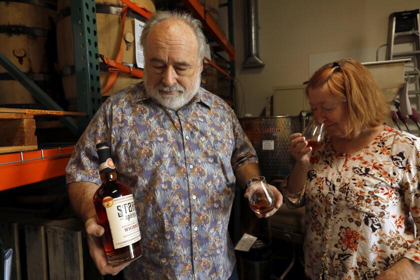 Pasadena, California-Oct. 30, 2020-Karen Robinson-Stark, right, and Greg Stark, left, at their distillery in Pasadena, California, photographed on Oct. 31, 2020. They try some of their award-winning whiskey. (Carolyn Cole / Los Angeles Times)