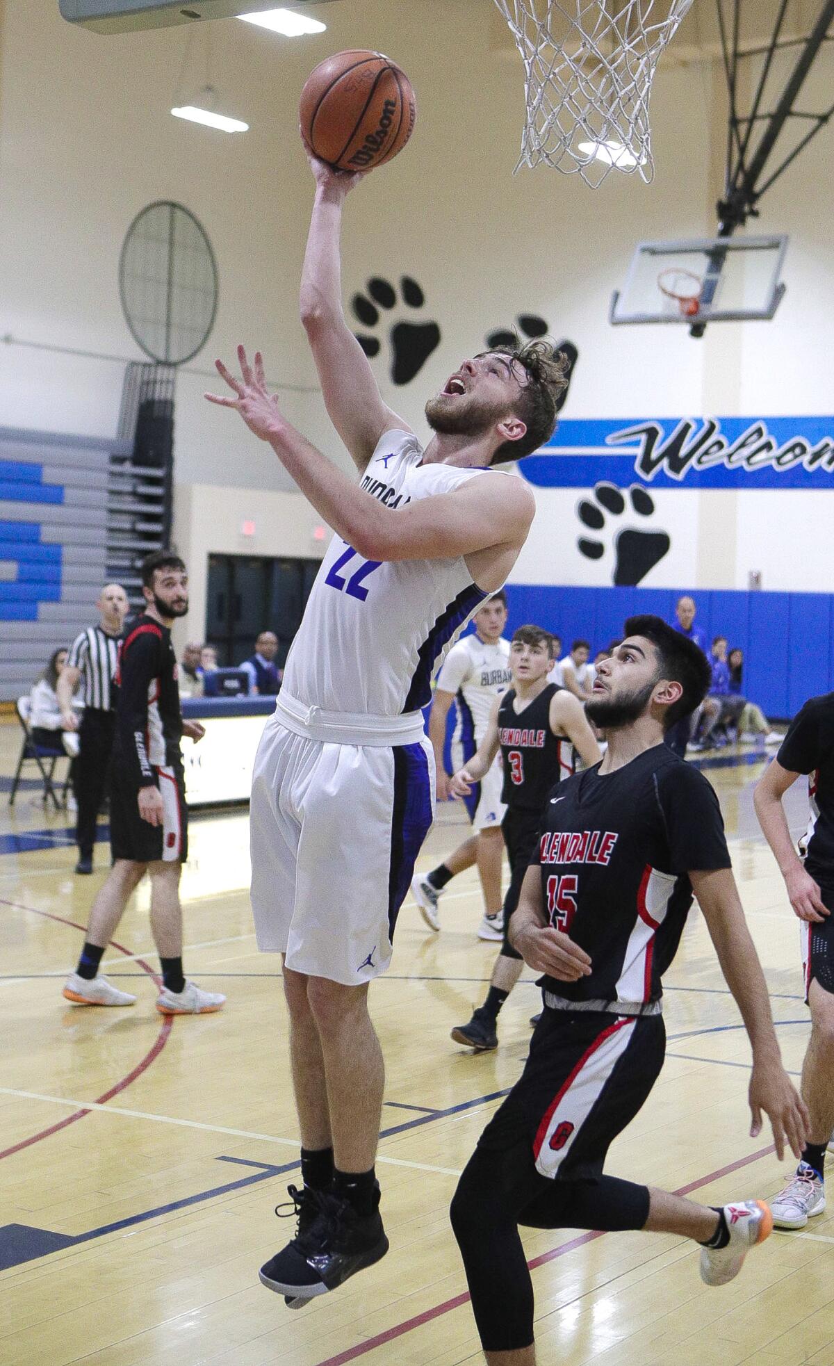 Burbank's Kelton Shea gets under the basket for a reverse layup against Glendale's Chance Snoody in a Pacific League boys' basketball game at Burbank High School on Friday, January 17, 2020.