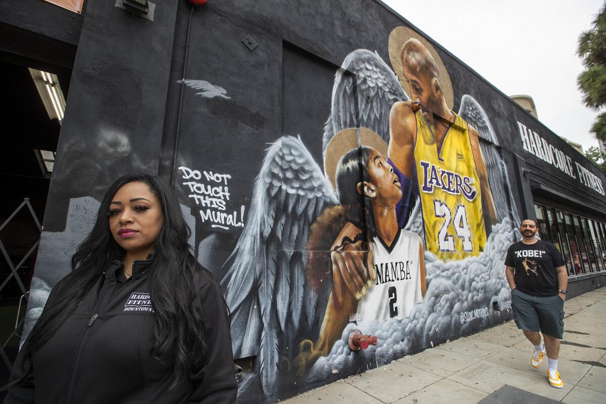 Cecilia Moran, the owner of Hardcore Fitness L.A., is photographed next to a mural of Kobe Bryant and his daughter Gianna.