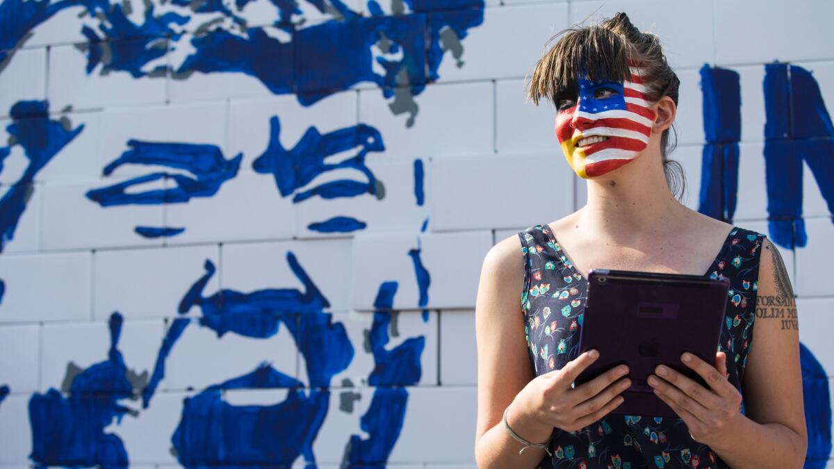 An activist with her face painted with the colors of the German and American flags joins a protest at the Brandenburg Gate in Berlin on Sept. 23.