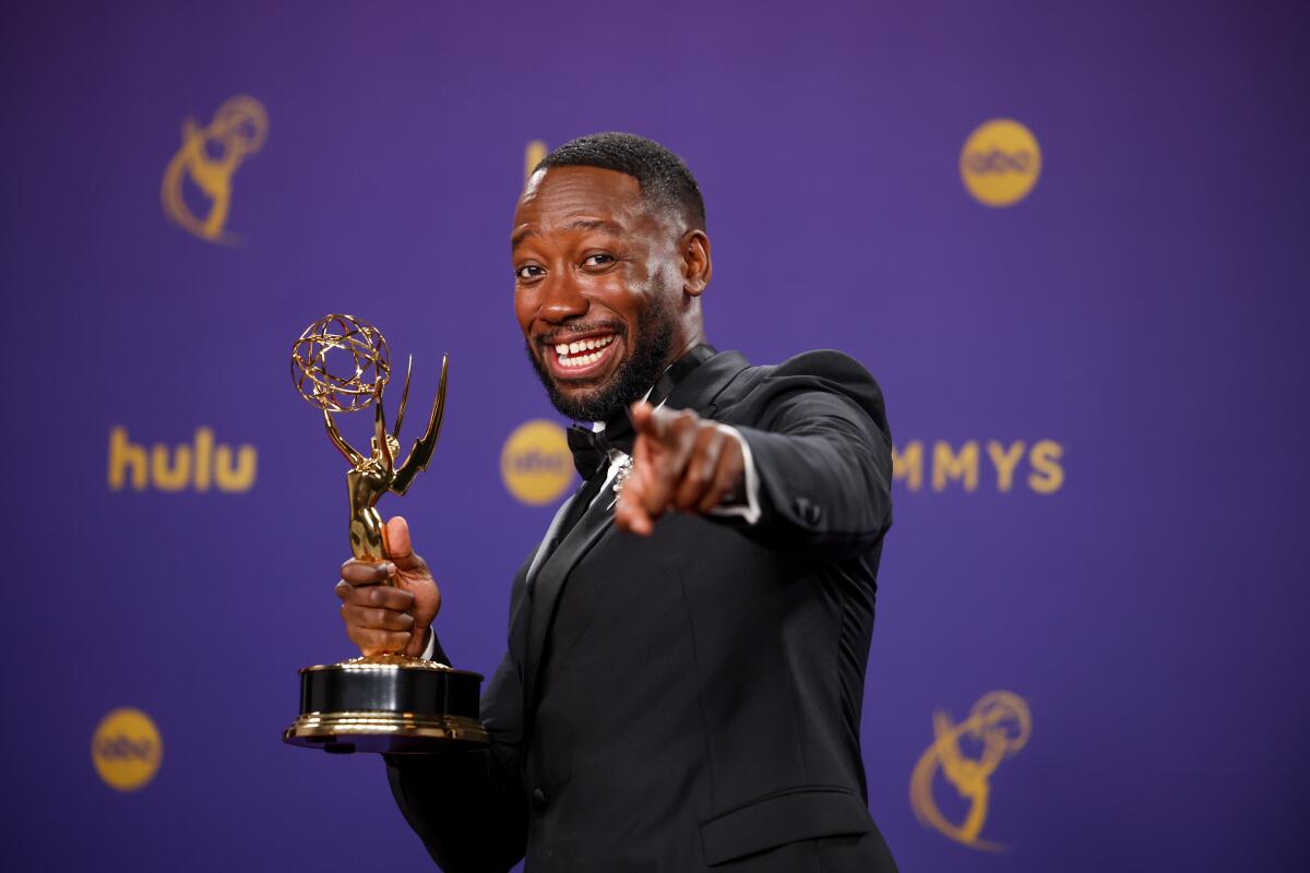 Lamorne Morris holds his Emmy backstage.