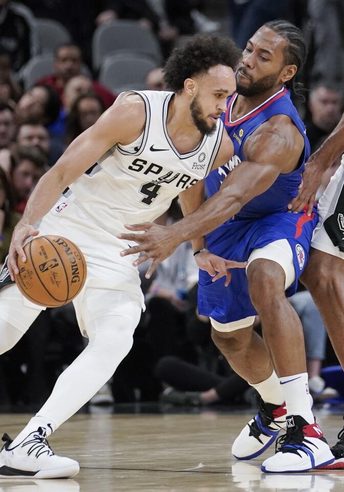 Spurs guard Derrick White (4) tries to drive to the basket against Clippers forward Kawhi Leonard during a game Nov. 29.