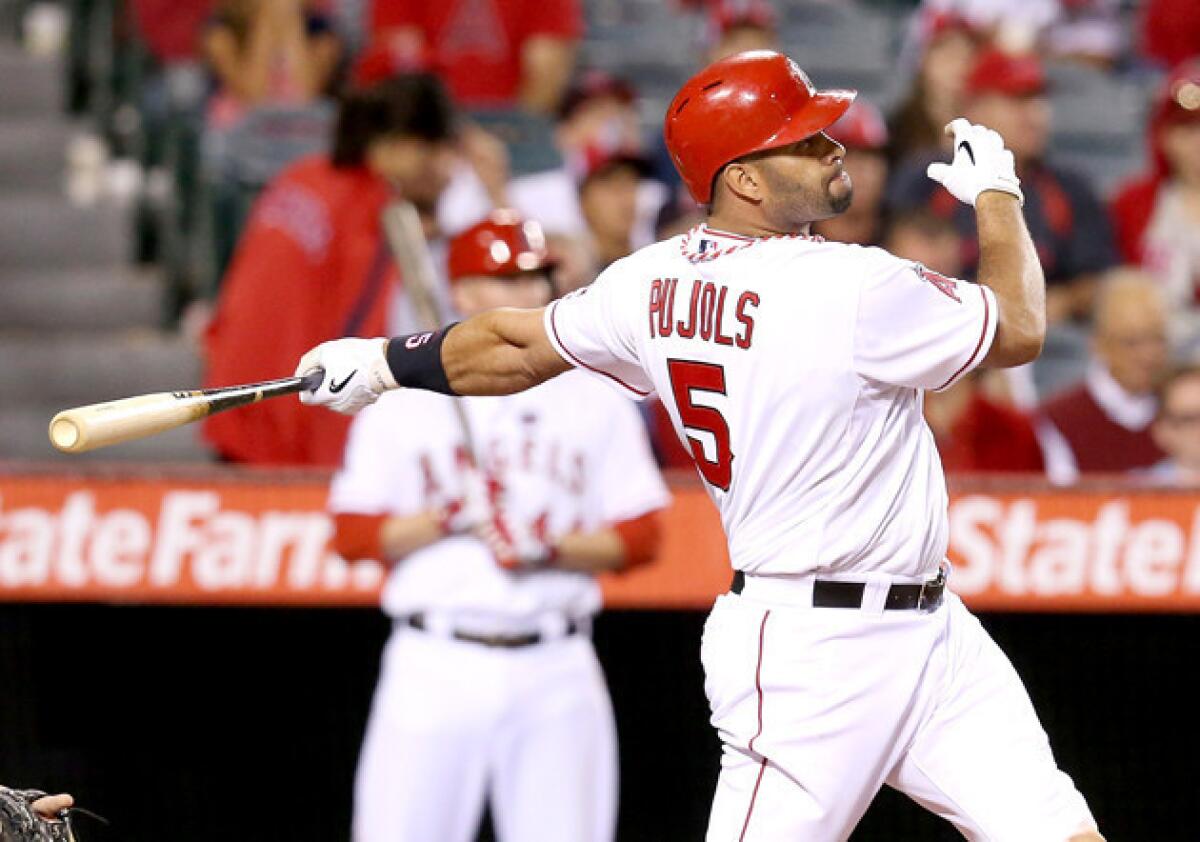 Angels' Albert Pujols hits a solo home run against the Seattle Mariners.