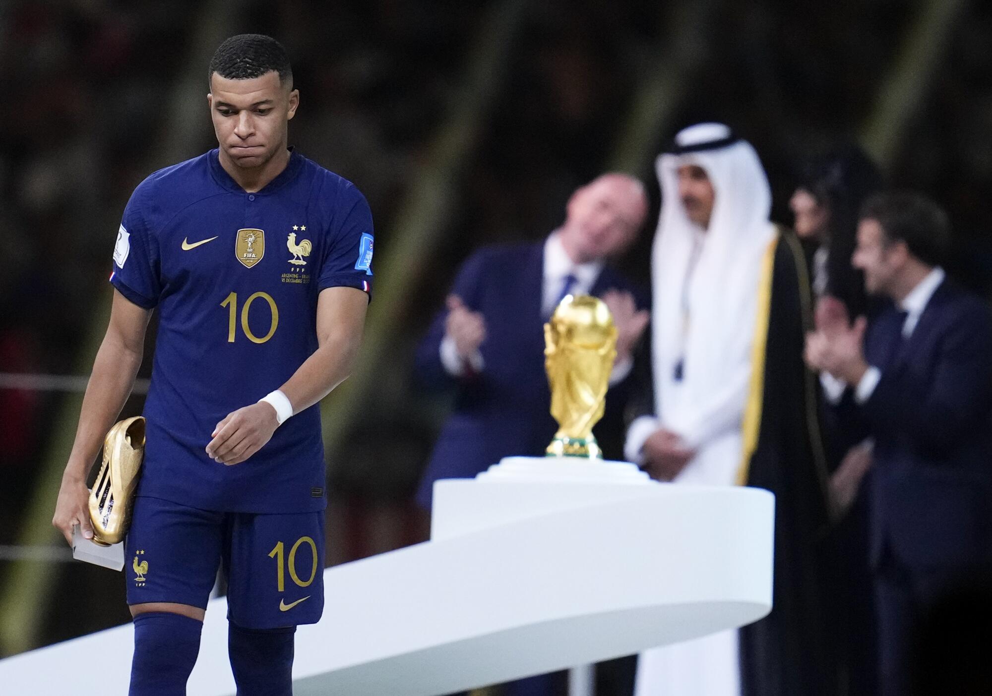 France's Kylian Mbappe walks with the Golden Boot award for top goal scorer of the tournament.