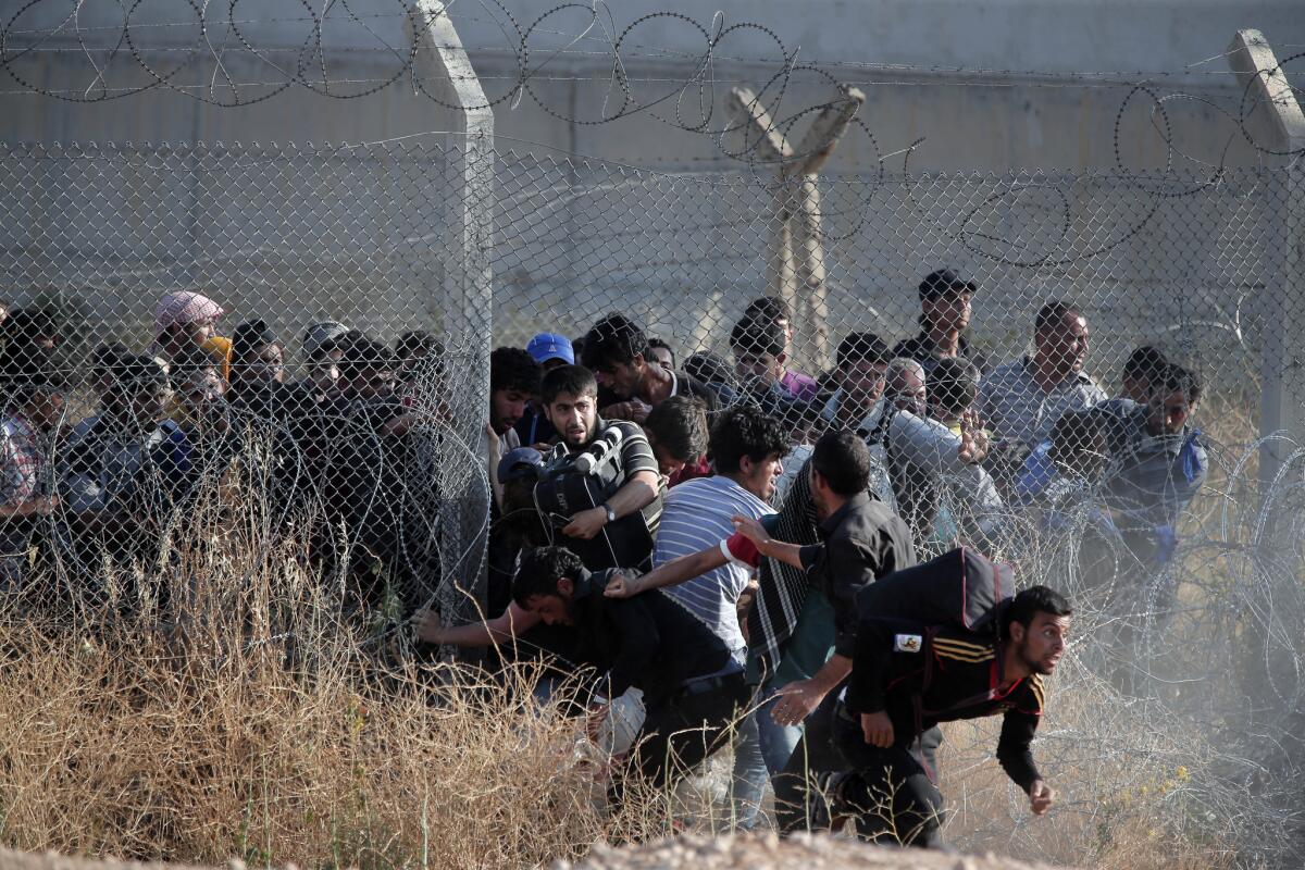 Syrian refugees sneak into Turkey after breaking the border fence and crossing from Syria in southeastern Turkey. The mass displacement of Syrians across the border into Turkey comes as Kurdish fighters and Islamic extremists clashed in the nearby city of Tal Abyad.