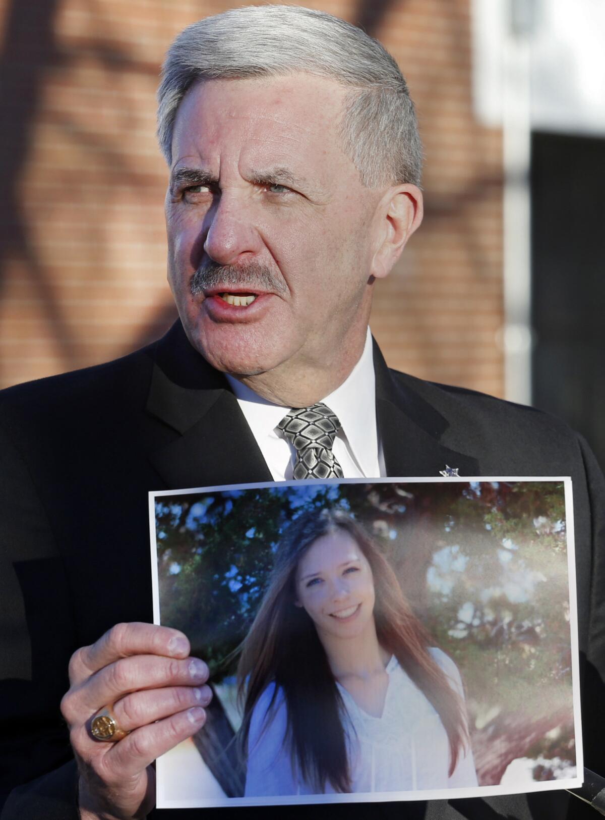 Arapahoe County Sheriff Grayson Robinson holds a picture of Claire Davis, the 17-year-old student who was shot at a Colorado high school Friday. She remained in critical condition Saturday.