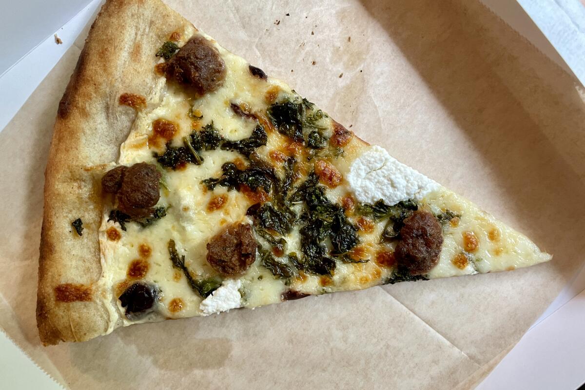 A slice of sausage and rapini pizza from Friends & Family Pizza Co.