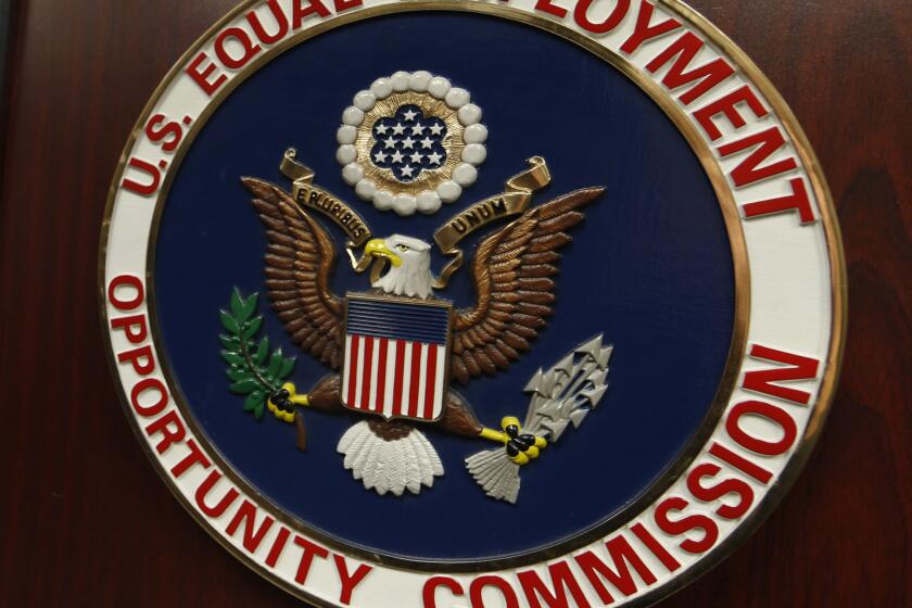 FILE - The emblem of the U.S. Equal Employment Opportunity Commission is shown on a podium in Vail, Colo., Tuesday, Feb. 16, 2016, in Denver. Charlotte Burrows, chair of the Equal Employment Opportunity Commission, told The Associated Press, Thursday, May 18, 2023, that the agency is trying to educate employers and technology providers about their use of these surveillance tools as well as AI tools that streamline the work of evaluating job prospects. (AP Photo/David Zalubowski, File)