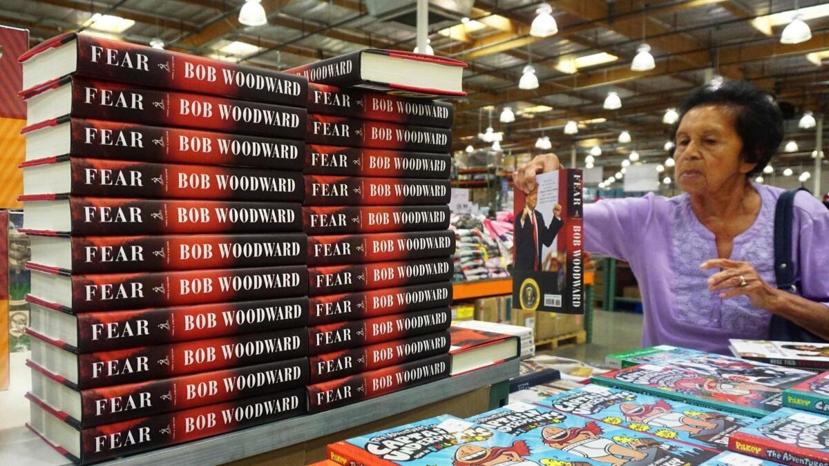 A customer looks at "Fear" by Bob Woodward at Costco in Alhambra.