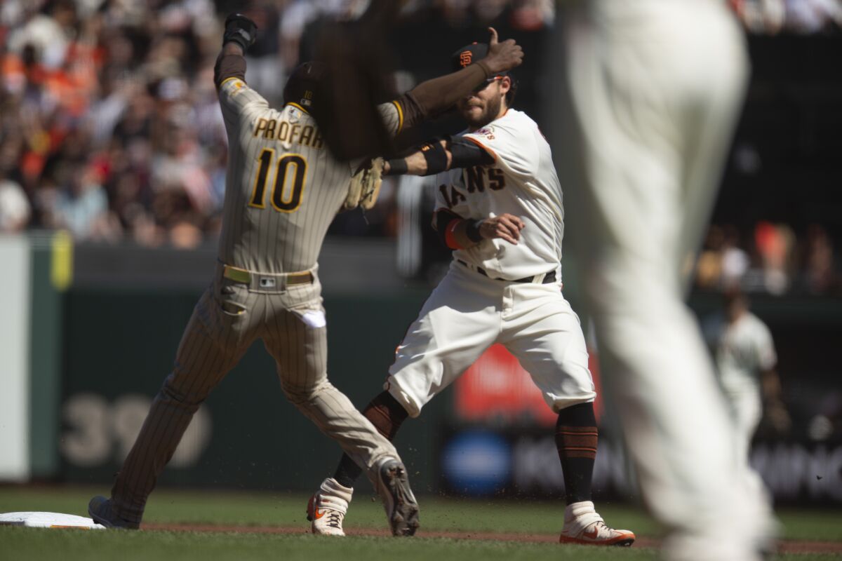 San Francisco Giants shortstop Brandon Crawford, back right, tags out San Diego Padres' Jurickson Profar (10) to complete a double play during the second inning of a baseball game, Saturday, Oct. 2, 2021, in San Francisco. Padres' Ha-Seong Kim was out at first base. (AP Photo/D. Ross Cameron)