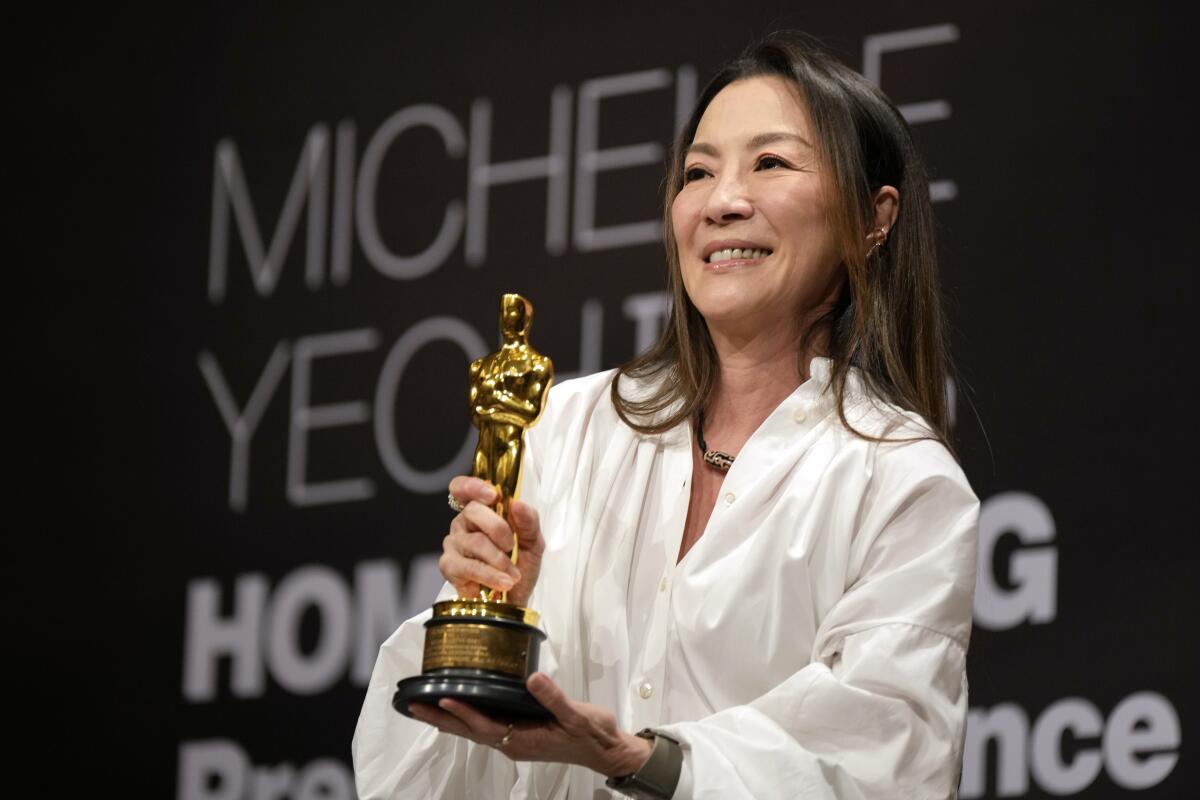 La actriz malasia Michelle Yeoh sostiene su estatuilla del Oscar durante una conferencia 