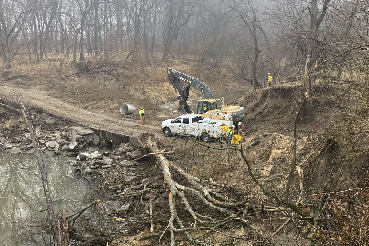 Washington County Road Department constructs an emergency dam to intercept an oil spill after a Keystone pipeline ruptured at Mill Creek in Washington County, Kanas, on Thursday, Dec 8, 2022. Vacuum trucks, booms and an emergency dam were constructed on the creek to intercept the spill. (Kyle Bauer/KCLY/KFRM Radio via AP)
