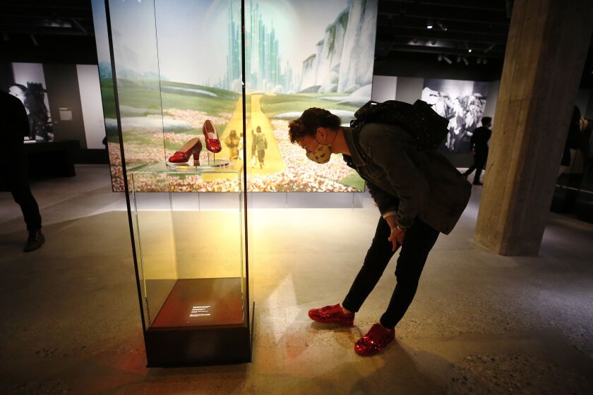 LOS ANGELES, CA - SEPTEMBER 30: Bruce Merkle wore his own ruby shoes as he enjoys the ruby slippers worn by Judy Garland from the "The Wizard of Oz" in the Academy Museum which opened its doors to the pubic following a ceremony marking the opening day for the Academy Museum of Motion Pictures. The ceremony included a ribbon cutting and civic dedication before opening its doors to first time visitors to the museum - the largest in the nation dedicated to movies and moviemaking. Academy Museum on Thursday, Sept. 30, 2021 in Los Angeles, CA. (Al Seib / Los Angeles Times).