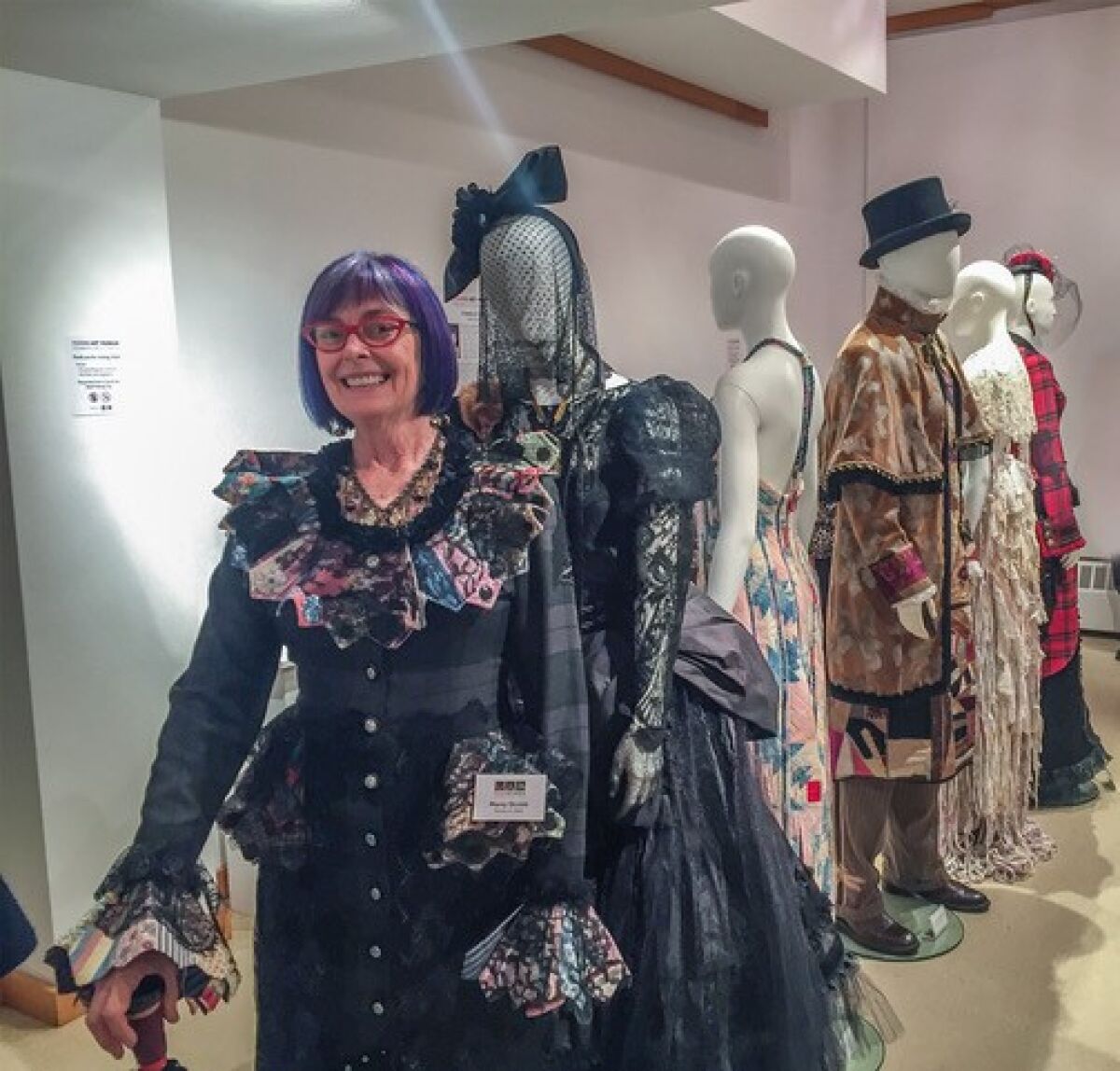 At the Oct. 19 opening, fiber artist Marty Ornish poses with a lineup of some of her up-cycled fashions in ‘Stories in Cloth.’