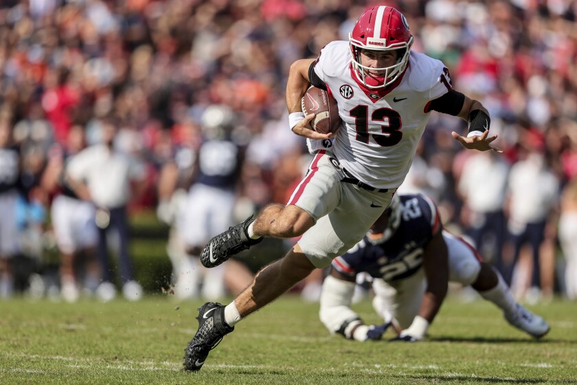 FILE - Georgia quarterback Stetson Bennett (13) carries the ball against Auburn during the first half of an NCAA college football game Saturday, Oct. 9, 2021, in Auburn, Ala. Georgia plays Alabama in the College Football Playoff national championship game on Jan. 10, 2022. (AP Photo/Butch Dill)