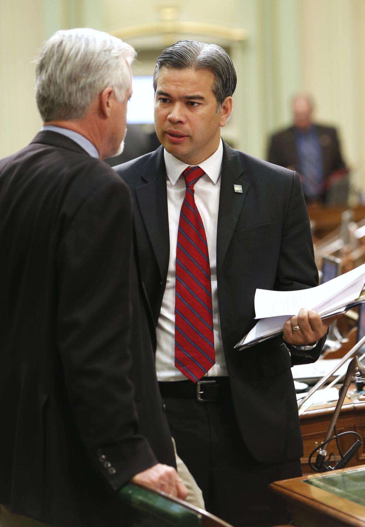 Assemblyman Rob Bonta (D-Oakland), right, talks with Assemblyman Wes Chesbro (D-Arcata) at the Capitol in Sacramento. Bonta introduced a measure that will allow noncitizens to volunteer as poll workers.