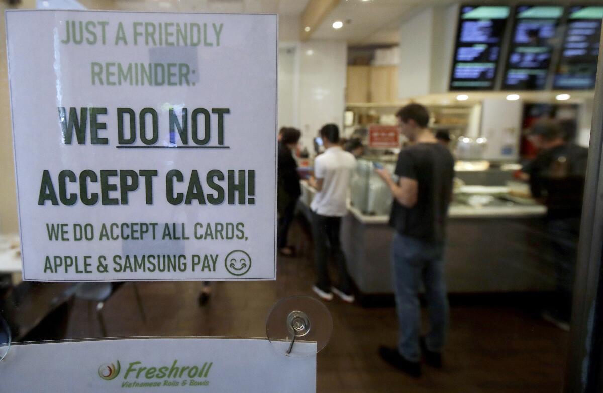 A sign alerts customers that cash is not accepted at Freshroll Vietnamese Rolls & Bowls in San Francisco.