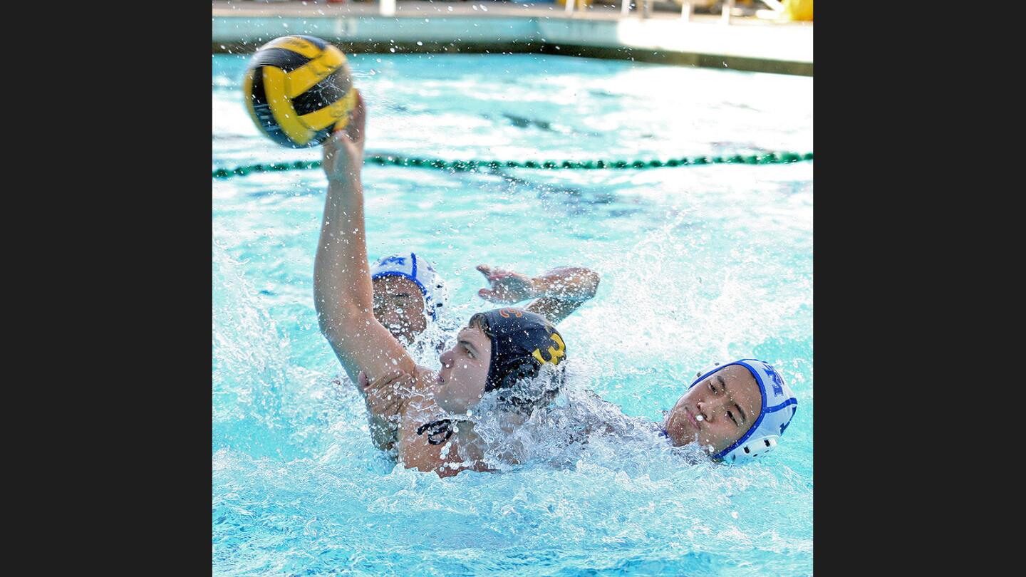 La Cañada's George Arakian, with San Marino's Charles Wong hand attempting to pull the shot off target, shoots and scores in a Rio Hondo League water polo match at La Cañada High School on Tuesday, October 18, 2016.