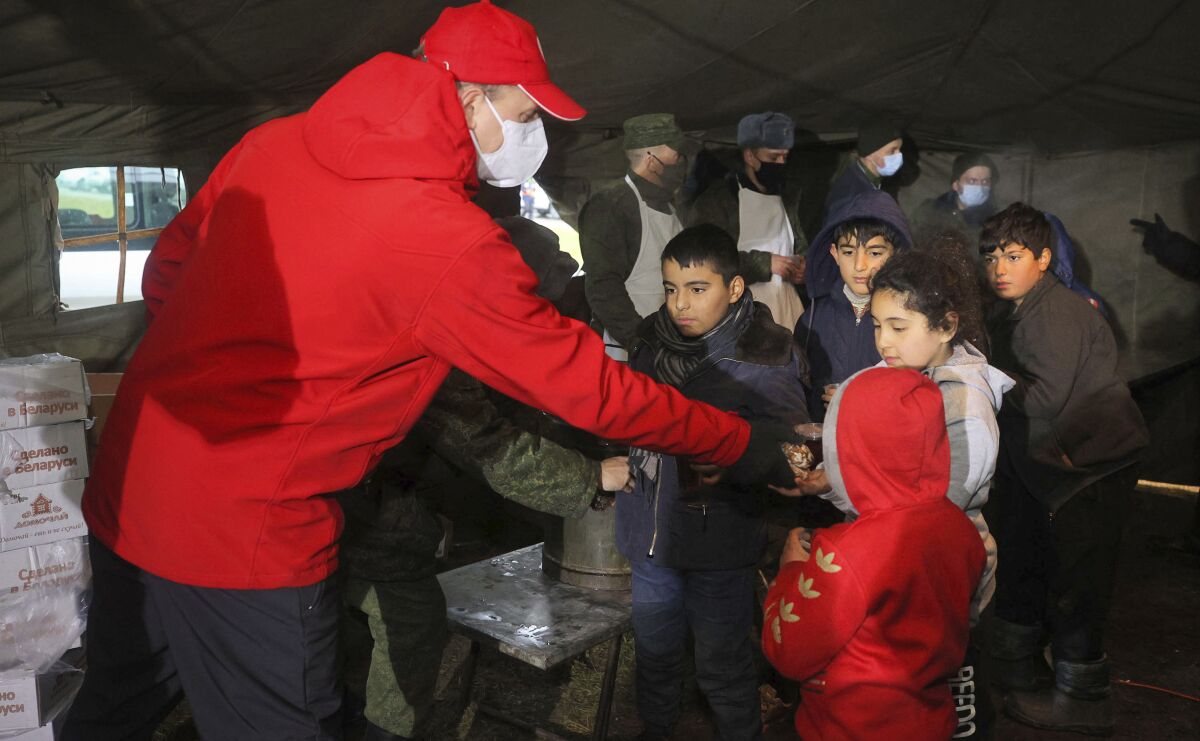 Red Cross employees distribute aid to migrants at a checkpoint on the Belarus-Poland border on Friday.