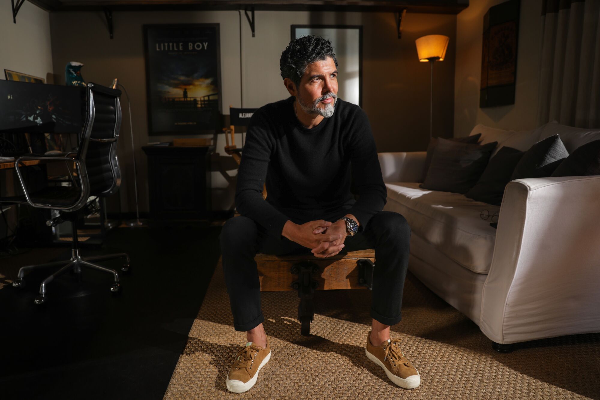 A man sits in a chair in his office. 