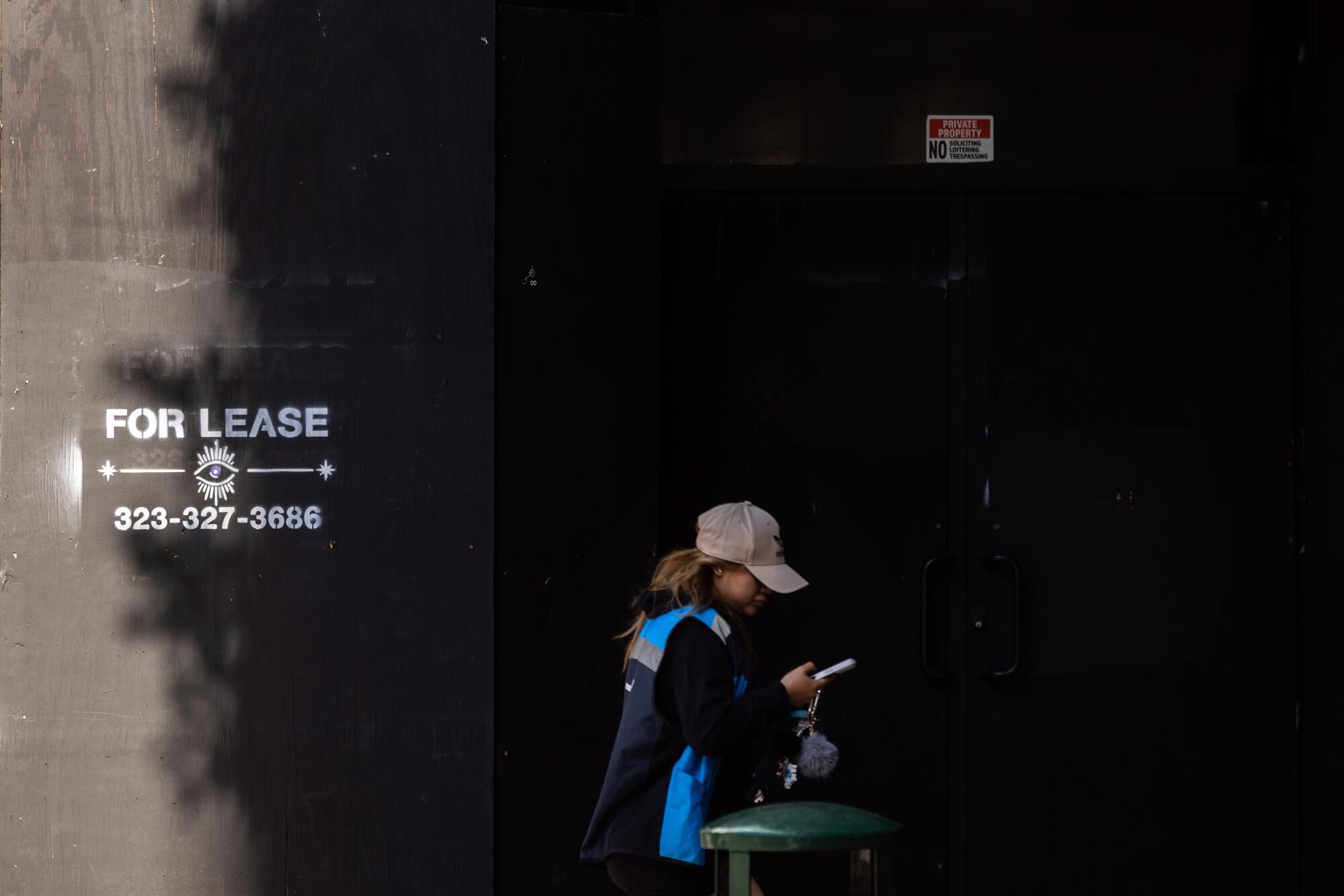 A pedestrian walks past a building for lease on Broadway in downtown Los Angeles.