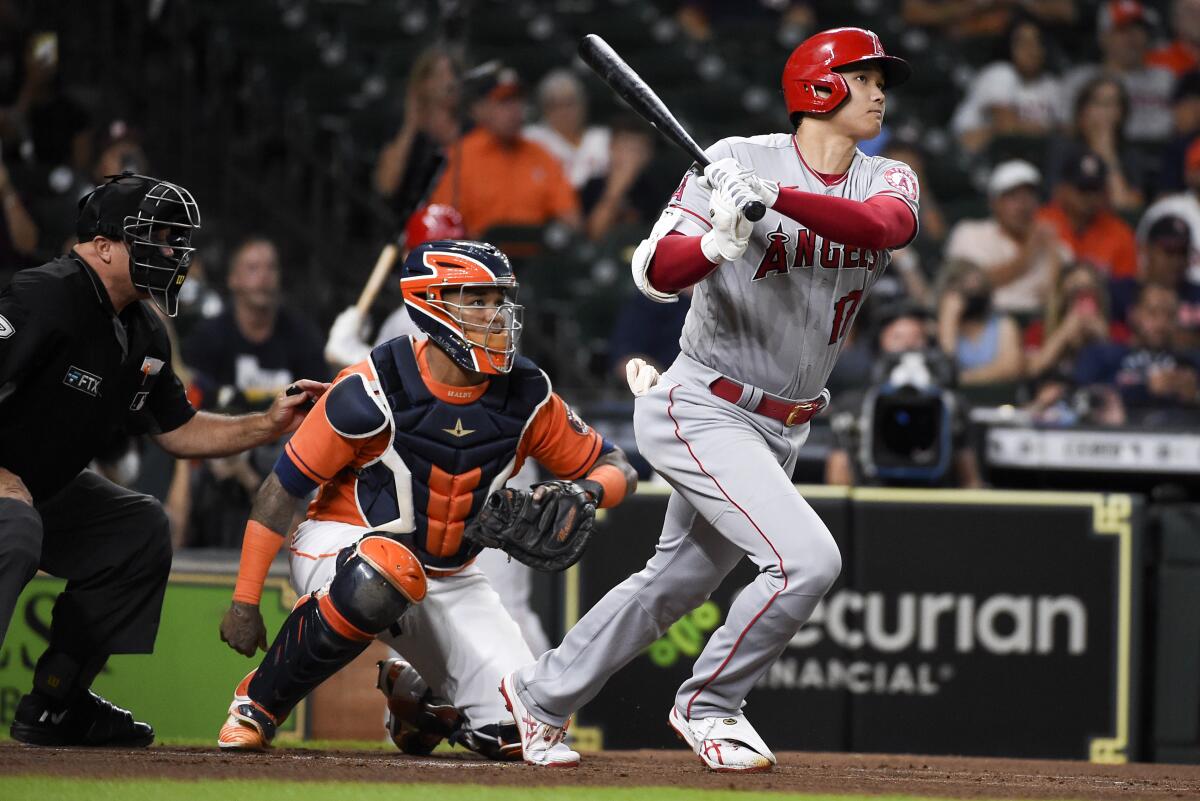Los Angeles Angels designated hitter Shohei Ohtani, right, hits a solo home run during the first inning of a baseball game against the Houston Astros, Friday, Sept. 10, 2021, in Houston. (AP Photo/Eric Christian Smith)